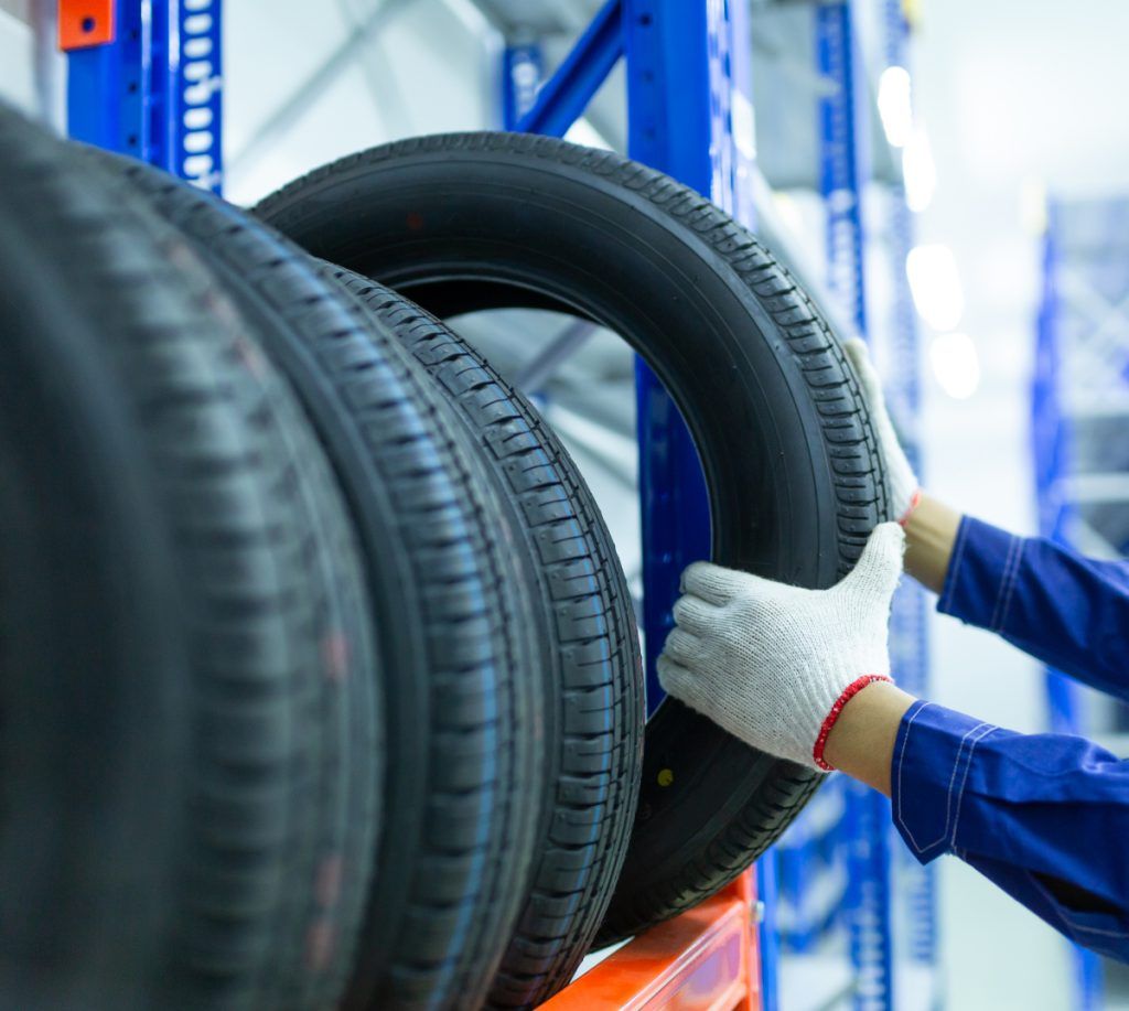 Mechanic holding a tyre - Order Tyres
